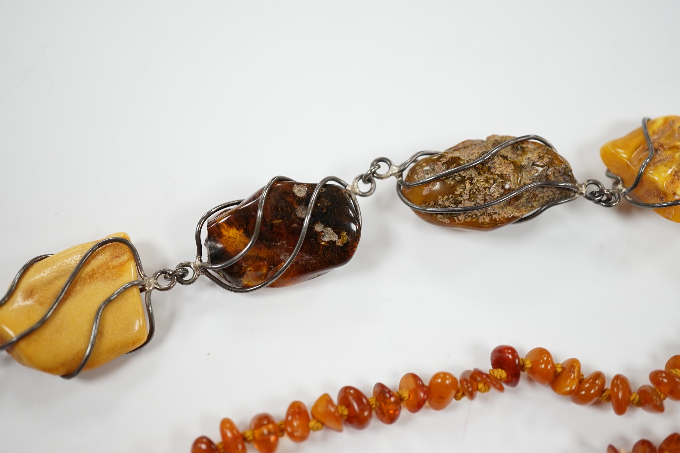 Two white metal and Baltic amber pebble set bracelets, one stamped 925, largest 25cm, a pair of similar drop earrings and an amber necklace.